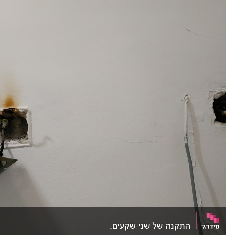 חוטי חשמל חשופים בקיר עם סימני שריפה